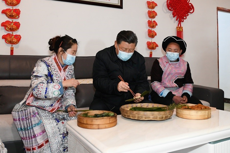 2021年2月3日下午，習(xí)近平在貴州畢節(jié)市黔西縣新仁苗族鄉(xiāng)化屋村苗族村民趙玉學(xué)家，同一家人邊聊家常邊制作當(dāng)?shù)貍鹘y(tǒng)節(jié)日食品黃粑。新華社記者 李學(xué)仁 攝