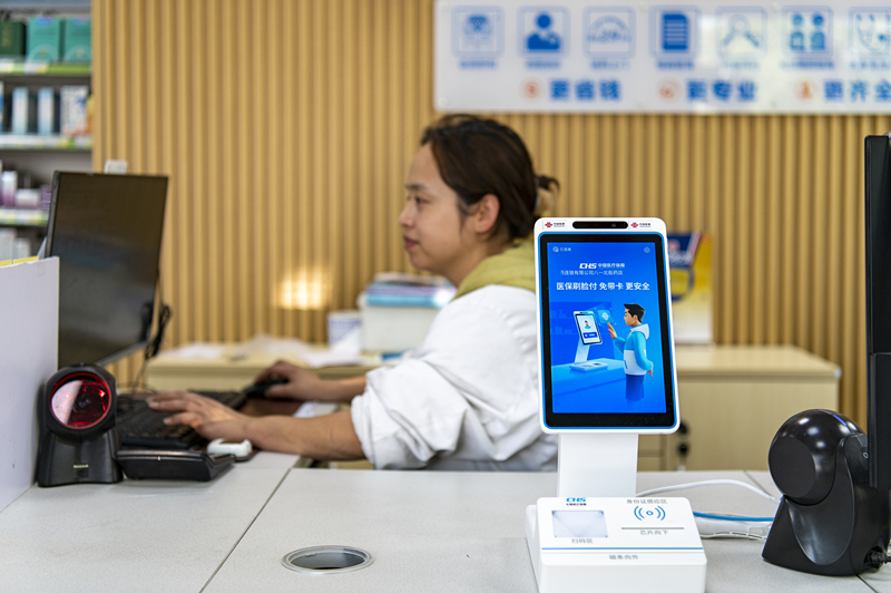 2024年4月10日，浙江金華市區(qū)一家民眾大藥房柜臺(tái)上設(shè)置著醫(yī)?！八⒛樦Ц丁睓C(jī)器，群眾看病更加便利。